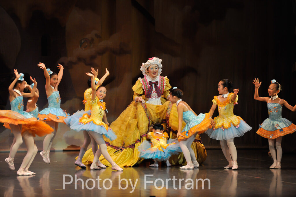 くるみ割り人形お菓子の国でギゴーニュおばさんのスカートの下に入ろうとする生徒たちを写した舞台写真