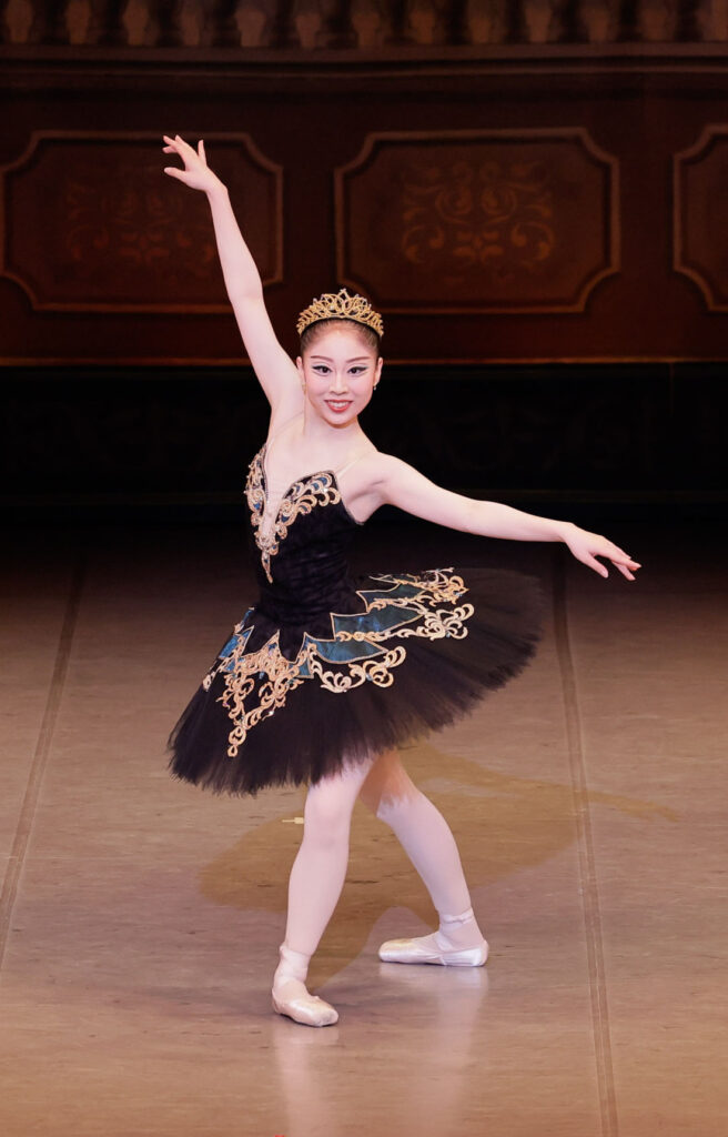 バレエ発表会で白鳥の湖の黒鳥役を踊る生徒を写した写真