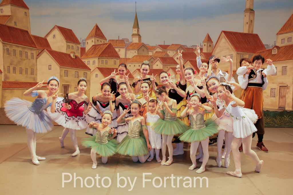 バレエ発表会が無事に終演を迎え舞台上で喜び合う生徒たちのスナップ写真